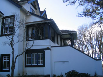 Two-storey Auckland weatherboard home freshly repainted in deep charcoal with white trim by APM