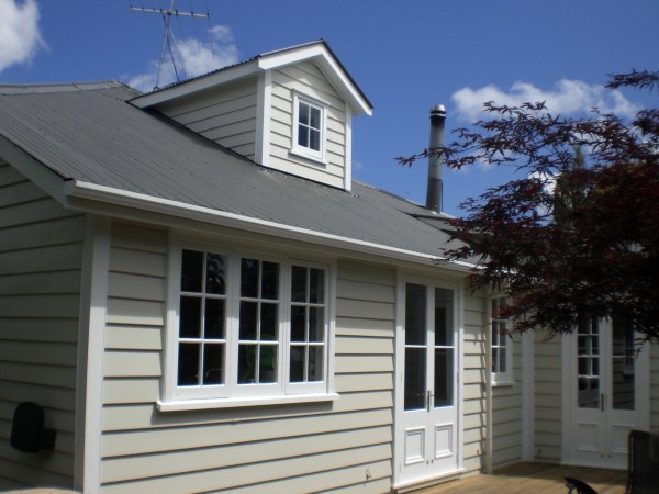 Repainted exterior of a weatherboard Auckland villa, fresh white coat with crisp window trim — preparation-first work by APM